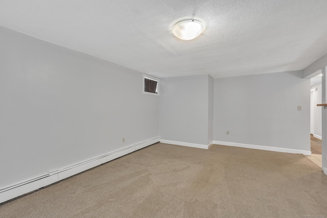 carpeted spare room with a baseboard heating unit and a textured ceiling