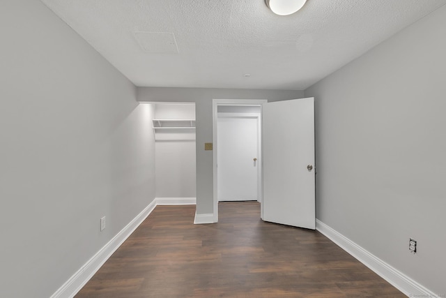 unfurnished bedroom with dark wood-type flooring and a textured ceiling