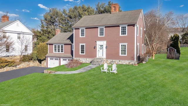 colonial-style house with a garage and a front yard