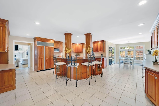 kitchen featuring pendant lighting, a kitchen breakfast bar, a center island, and light tile patterned floors