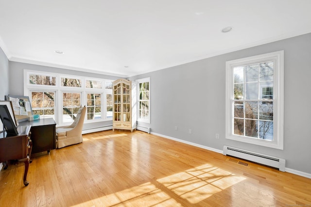 interior space with crown molding, light hardwood / wood-style flooring, and baseboard heating