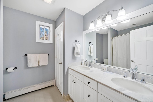 bathroom featuring a baseboard radiator, vanity, toilet, and tile patterned floors