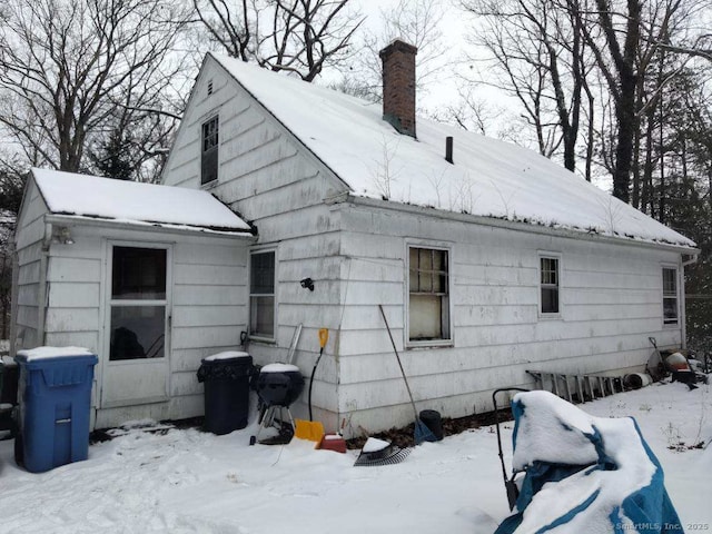 view of snow covered rear of property