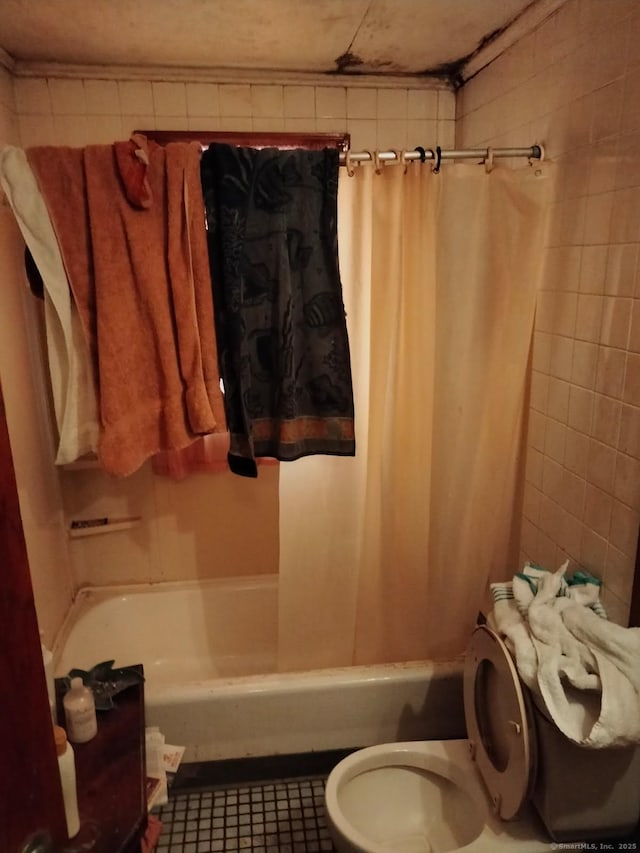 bathroom with shower / bath combo, tile patterned floors, and toilet