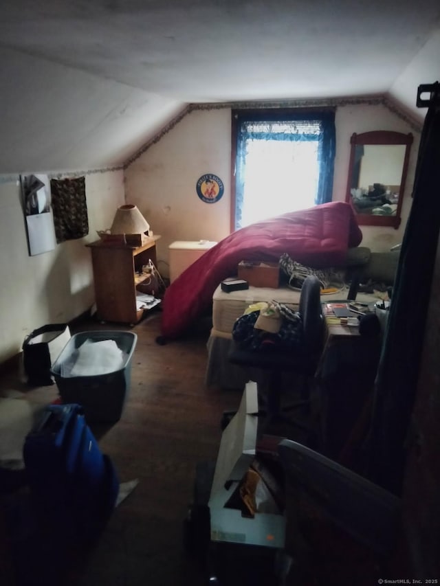 additional living space with hardwood / wood-style floors and vaulted ceiling