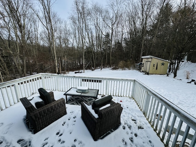 snow covered deck featuring a shed