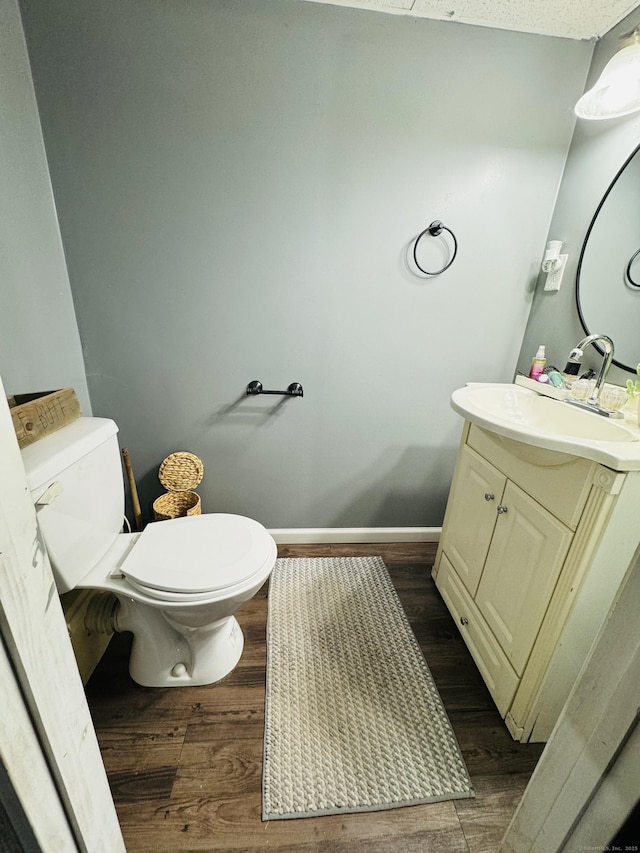 bathroom with vanity, hardwood / wood-style flooring, and toilet