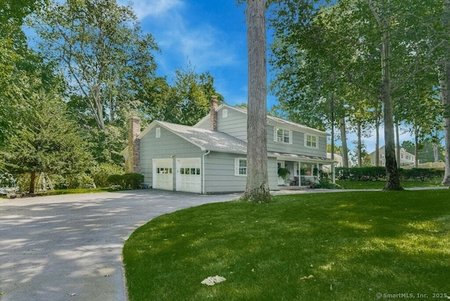 view of front of property featuring a garage, a porch, and a front lawn