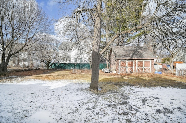 yard covered in snow with an outbuilding