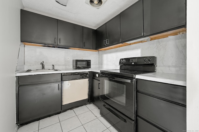 kitchen featuring black appliances, light countertops, and a sink