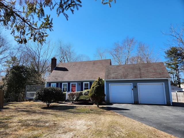 view of front of house featuring a garage, fence, driveway, a chimney, and a front yard