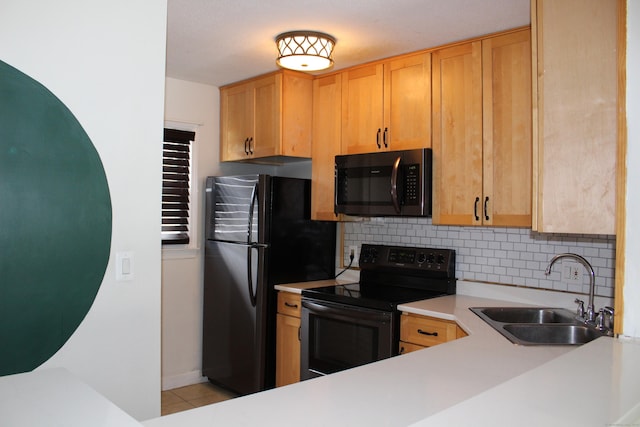 kitchen featuring light brown cabinets, sink, decorative backsplash, and black appliances