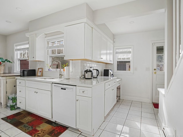 kitchen with a sink, white cabinetry, light countertops, and dishwasher