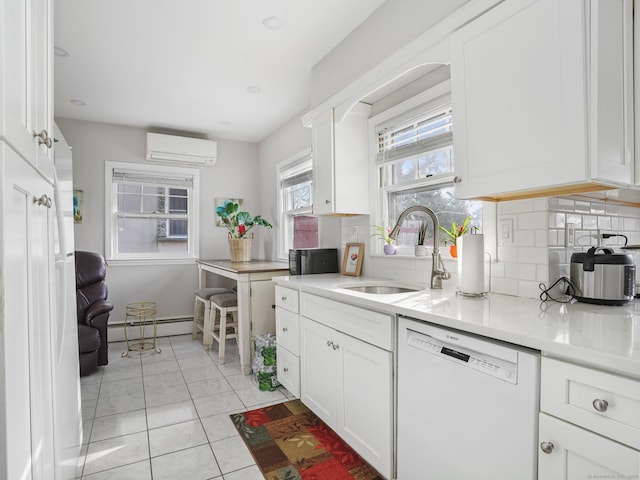 kitchen with backsplash, white cabinets, a sink, a wall mounted air conditioner, and dishwasher