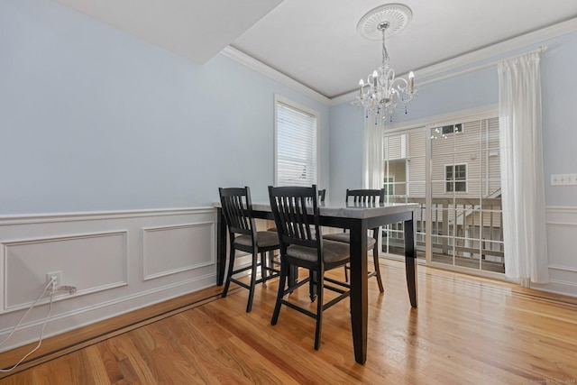 dining room with ornamental molding, a chandelier, and light hardwood / wood-style floors