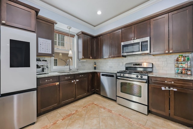 kitchen with sink, stainless steel appliances, tasteful backsplash, dark brown cabinetry, and ornamental molding