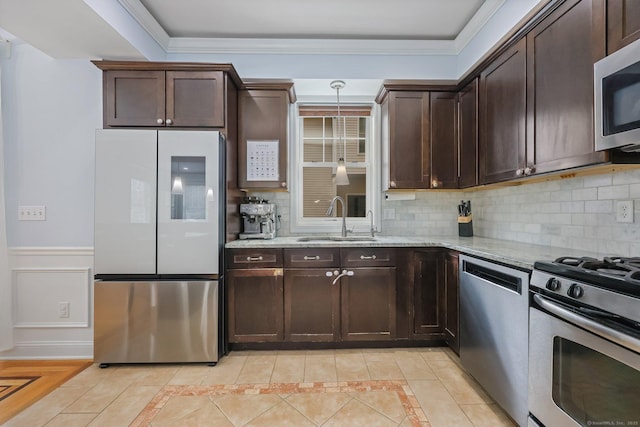 kitchen with tasteful backsplash, stainless steel appliances, light stone countertops, and sink