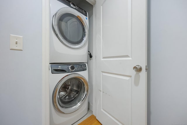 clothes washing area with stacked washer and clothes dryer