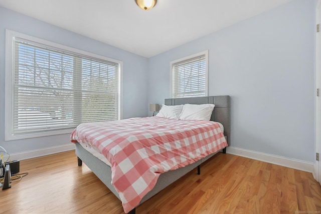 bedroom featuring multiple windows and light hardwood / wood-style flooring