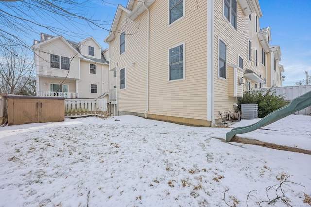 snow covered property with a hot tub and central AC