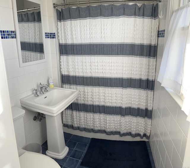 bathroom featuring tile walls, toilet, and tile patterned floors