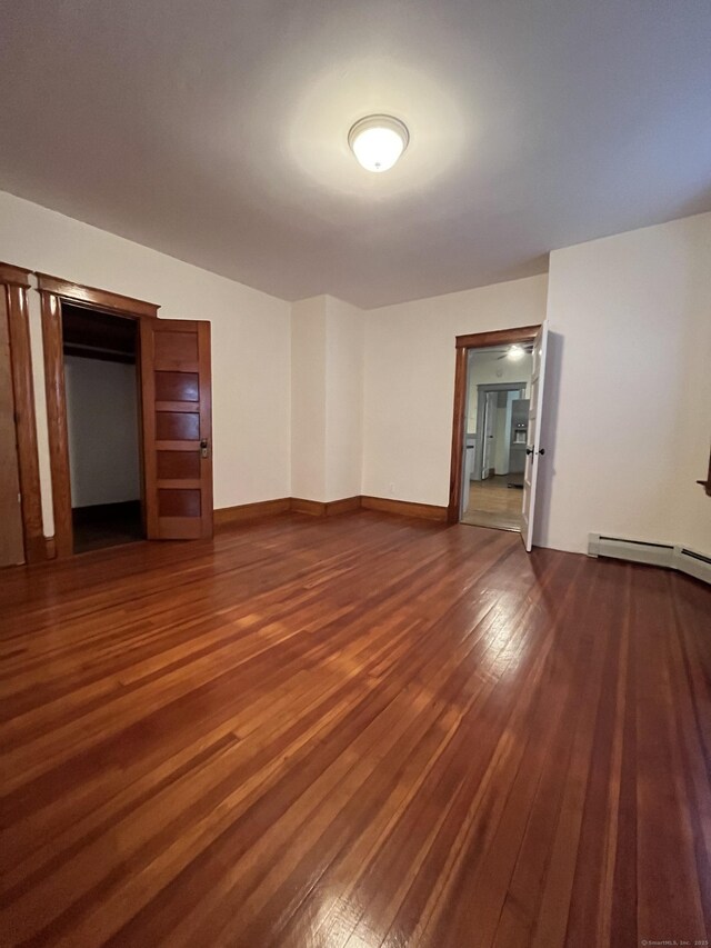 interior space with dark hardwood / wood-style flooring and baseboard heating