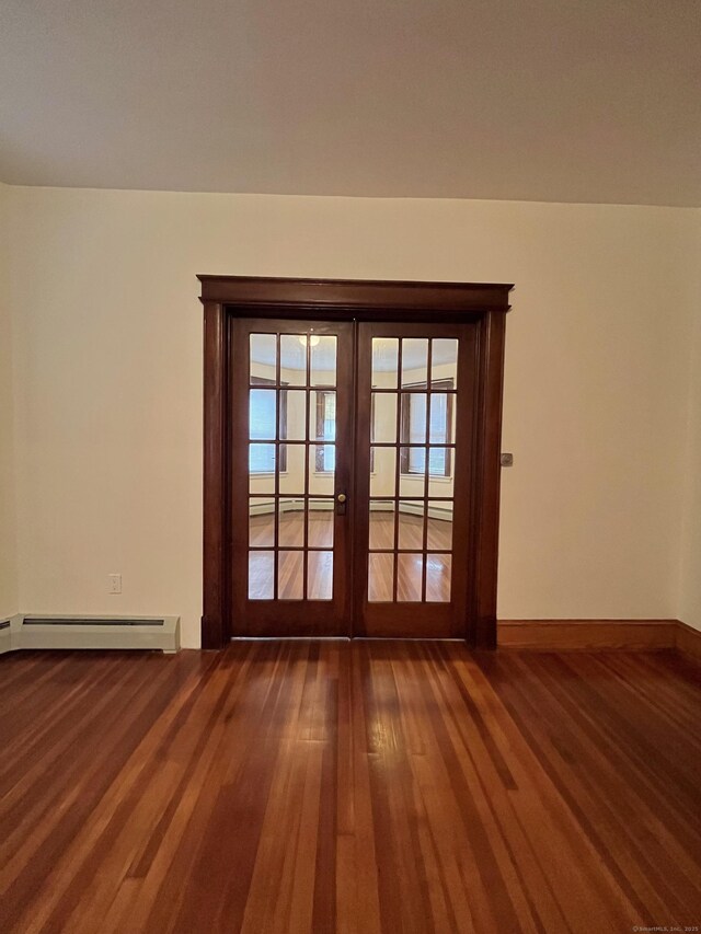 spare room featuring a baseboard radiator, hardwood / wood-style floors, and french doors