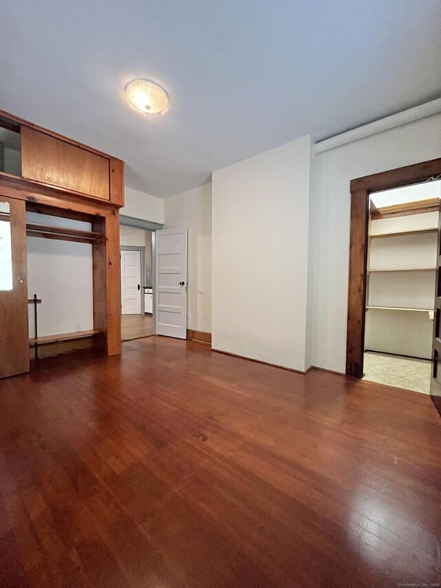 unfurnished bedroom with dark hardwood / wood-style flooring