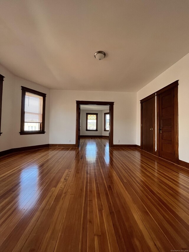 unfurnished living room with a healthy amount of sunlight and dark hardwood / wood-style flooring