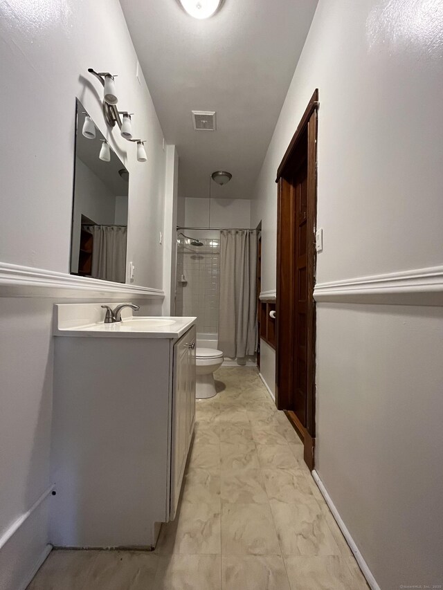 full bathroom featuring tiled shower / bath combo, vanity, and toilet