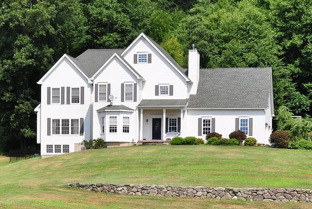 traditional home featuring a chimney and a front yard