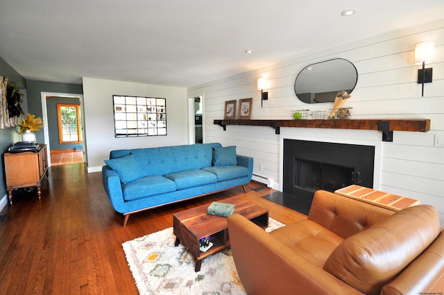 living area with baseboards, a fireplace with flush hearth, wood finished floors, baseboard heating, and recessed lighting