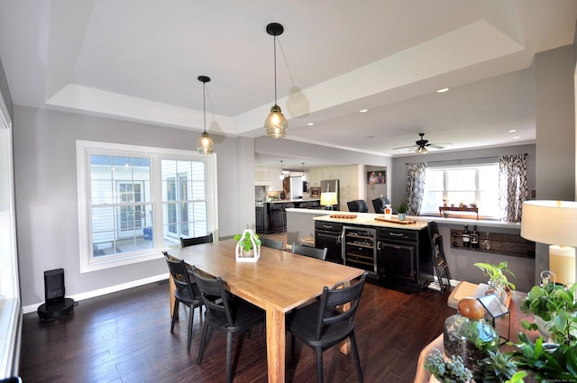 dining room with baseboards, a raised ceiling, a ceiling fan, dark wood-style floors, and wine cooler