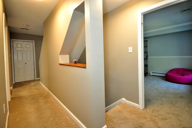 corridor with a baseboard radiator, carpet, visible vents, and baseboards