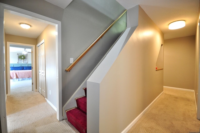 corridor with stairway, baseboards, and carpet flooring