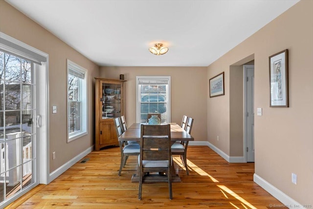 dining space with a wealth of natural light and light hardwood / wood-style flooring