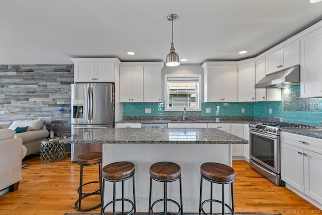 kitchen featuring white cabinetry, decorative light fixtures, and appliances with stainless steel finishes