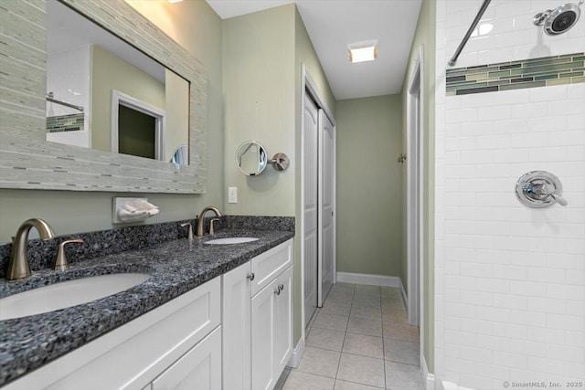 bathroom featuring tile patterned flooring, vanity, and a tile shower