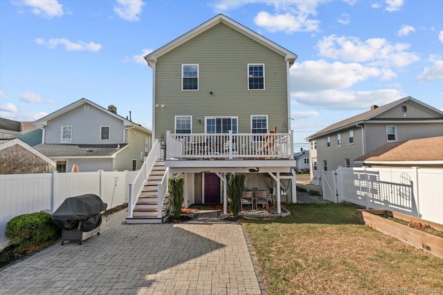 back of house featuring a wooden deck, a yard, and a patio