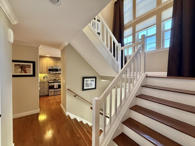 stairs featuring ornamental molding and hardwood / wood-style floors