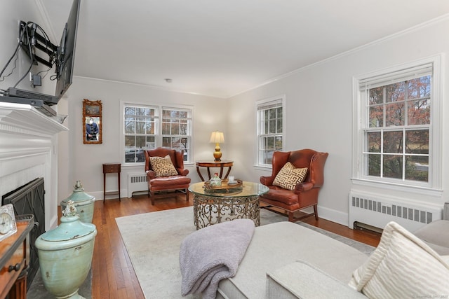 living room with radiator heating unit, ornamental molding, and dark hardwood / wood-style floors