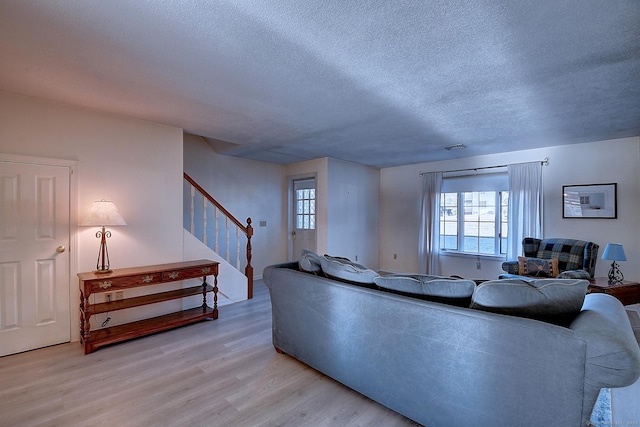 living room featuring a textured ceiling and light hardwood / wood-style floors