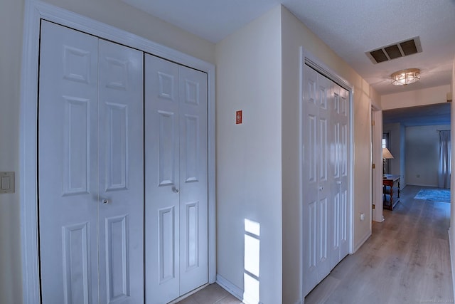 corridor with light hardwood / wood-style floors