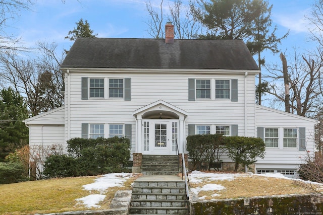 colonial inspired home featuring entry steps and a chimney