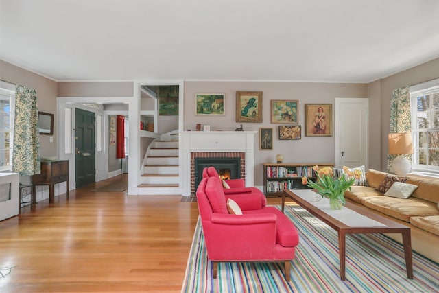 living area with light wood finished floors, stairs, and a fireplace