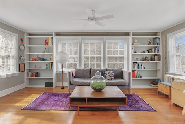 living area with ceiling fan, light wood-type flooring, built in features, and baseboards