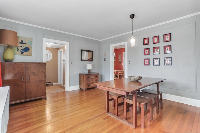 dining area featuring ornamental molding, baseboard heating, light wood-type flooring, and baseboards