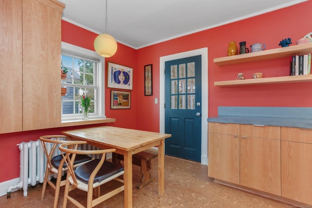 dining area with radiator heating unit and crown molding