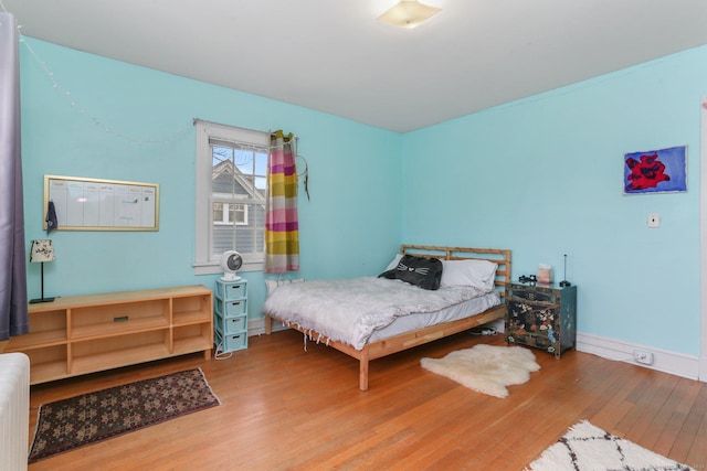 bedroom featuring radiator, wood-type flooring, and baseboards