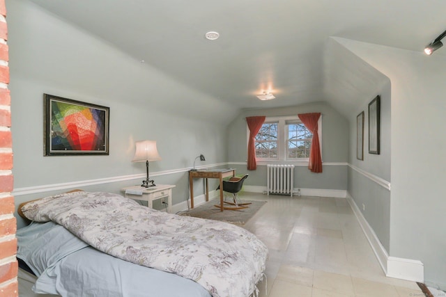 bedroom featuring lofted ceiling, radiator, and baseboards